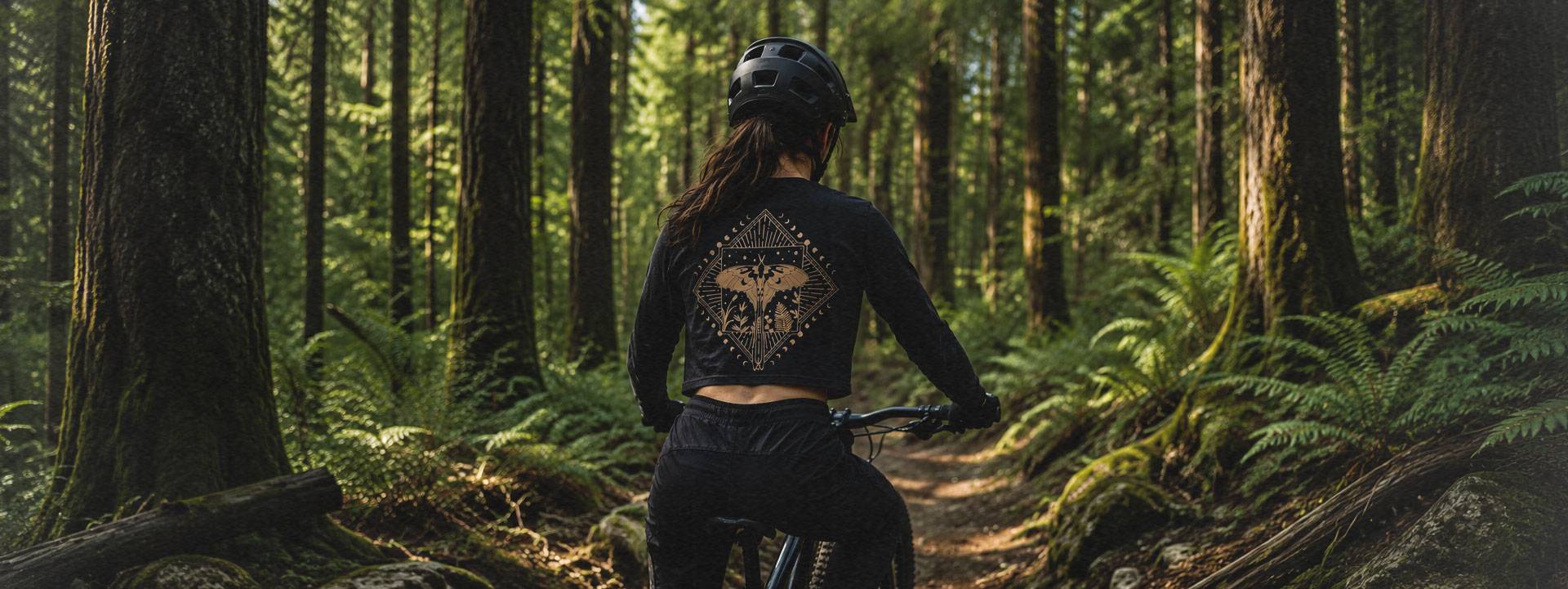 Rider in a Winch & Plummet Air Ape t-shirt overlooking alpine peaks and wildflowers Rider in a Winch & Plummet Air Ape t-shirt overlooking alpine peaks and wildflowers